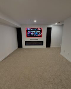 Finished basement media room with clean white walls and recessed lighting by Ottawa painters
