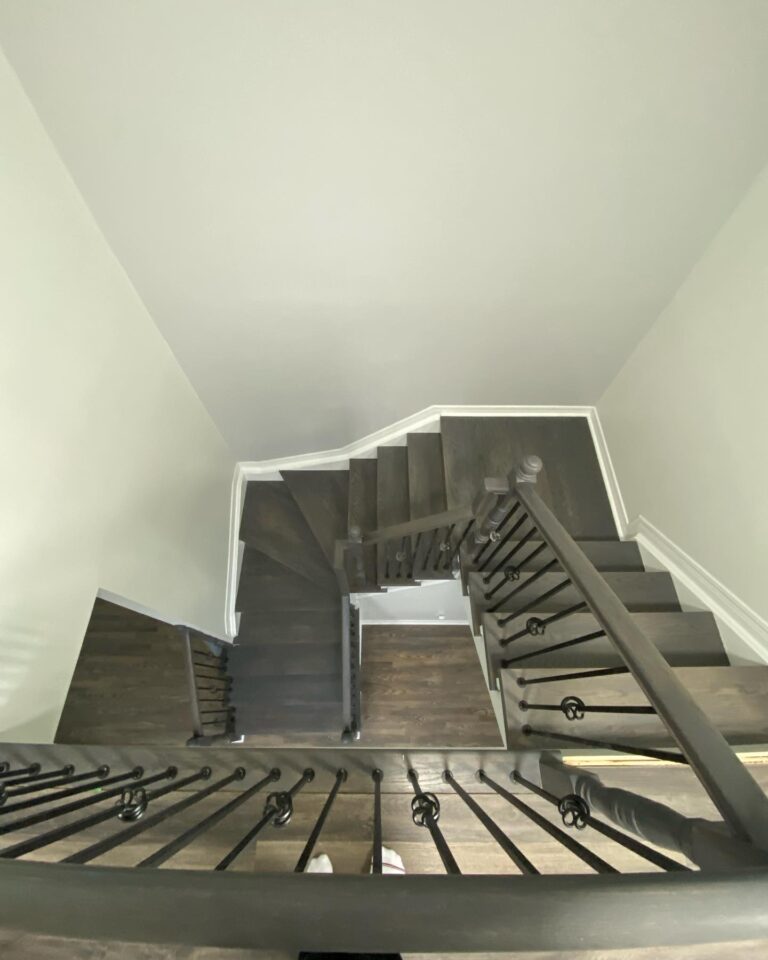 Wood Staining Services Ottawa,painting services ottawa Completed interior staircase renovation with stained wood treads and freshly painted white risers by Silver Hawk Painting.