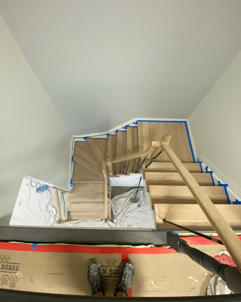 Wood Staining Services Ottawa,painting services ottawa Interior wooden staircase in Ottawa masked with blue tape and paper in preparation for wood staining and painting services by Silver Hawk Painting.