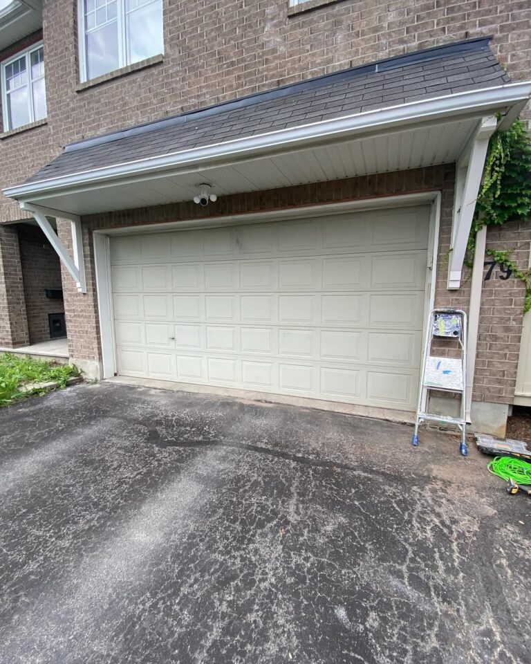 Before garage door painting Ottawa: an older white garage door being prepared for a professional color change.