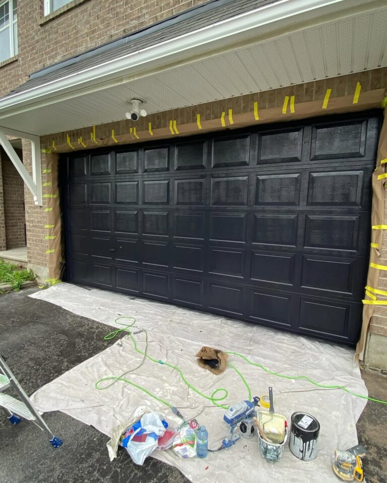 After professional garage door painting Ottawa: a modern, matte black finish on a residential garage.